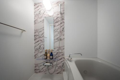 a white bathroom with a tub and a mirror at winco - Vacation STAY 06658v in Tokyo