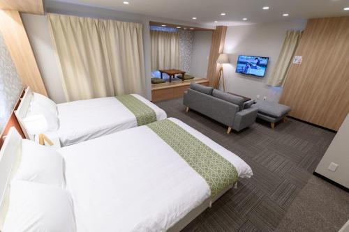 a hotel room with two beds and a couch at winco - Vacation STAY 05557v in Tokyo