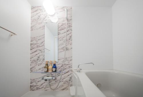 a white bathroom with a tub and a mirror at winco - Vacation STAY 05545v in Tokyo