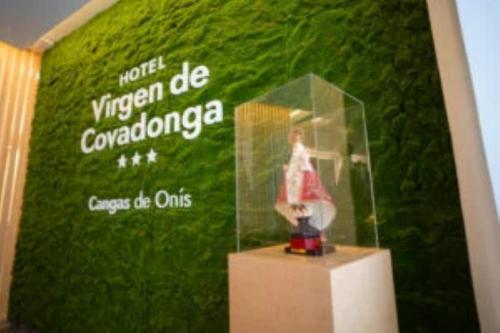 a green wall with a woman in a dress in a display case at Hotel Virgen de Covadonga in Cangas de Onís