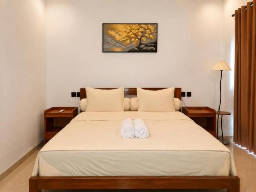 a bedroom with a bed with two white shoes on it at Jou Trekking Guesthouse in Senaru
