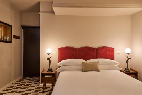 ein Schlafzimmer mit einem großen Bett mit rotem Kopfteil in der Unterkunft Le Berger Latroupe Hotel in Brüssel