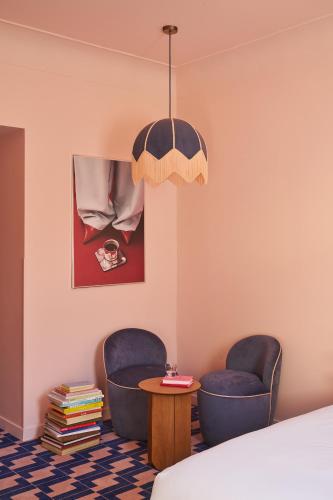 ein Schlafzimmer mit zwei Stühlen und einem Tisch in der Unterkunft Le Berger Latroupe Hotel in Brüssel