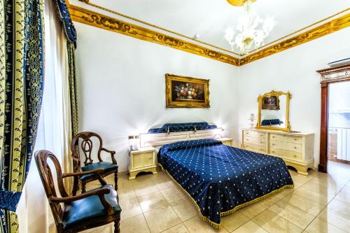 1 dormitorio con 1 cama azul y 1 silla en Euro Hotel Iglesias, en Iglesias
