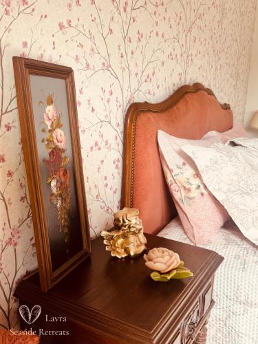 a bed with a wooden table with a picture on it at Vintage Boutique Room in Lavra