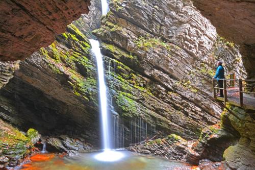 a person standing on a platform next to a waterfall at Sonnmatt Bergpension & Gesundheitszentrum in Ebnat