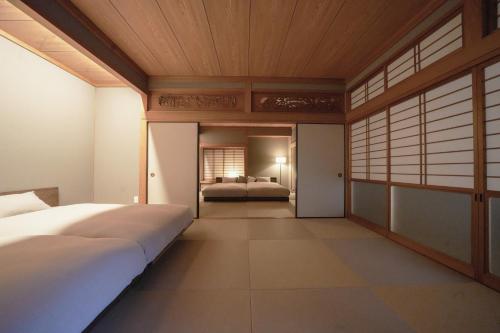 a bedroom with a bed and a bedroom with atained at Hakusyu - Vacation STAY 11460v in Aso