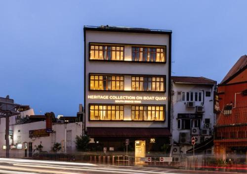 a tall building with lit windows on a city street at Heritage Collection on Boat Quay - South Bridge Wing - Mobile App Check-In in Singapore