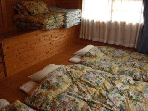 a bedroom with two beds and a couch and a window at Cottage Izu,com - Vacation STAY 07073v in Minamiizu