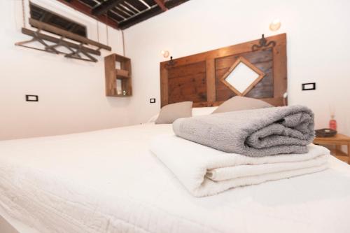 uma pilha de toalhas sentadas em cima de uma cama em Casa Sant'Agostino CITRA LT-2407 em Génova