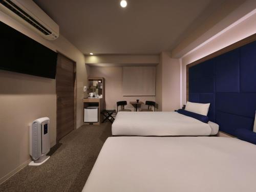 a hotel room with a large bed and a tv at Dotonbori Crystal Hotel - Vacation STAY 77468v in Osaka