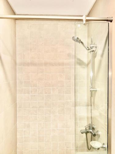 a shower in a bathroom with a glass door at Ajmal Makan City in Sharjah