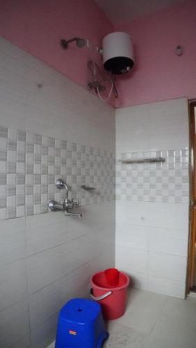 a bathroom with a red bucket and a faucet at Nilachal Homes in Guwahati