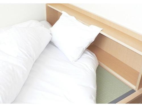 a bed with white sheets and a pillow at Anan Station Hotel - Vacation STAY 11048v in Anan