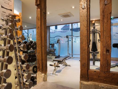 een fitnessruimte met halters en fitnessapparatuur bij Hôtel Jacques De Molay in Parijs