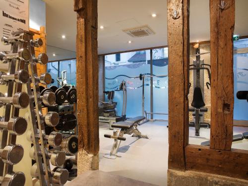 a gym with dumbbells and exercise equipment at Hôtel Jacques de Molay - Fitness & Sauna in Paris