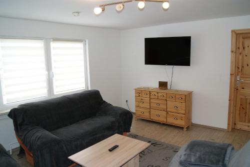 a living room with a couch and a flat screen tv at Hotel Braunlage in Braunlage