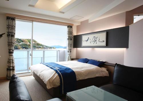 a bedroom with a bed and a large window at Hotel Mare - Vacation STAY 96730v in Kure