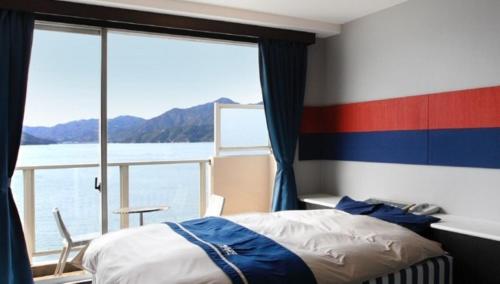 a bedroom with a bed and a view of the water at Hotel Mare - Vacation STAY 59171v in Kure