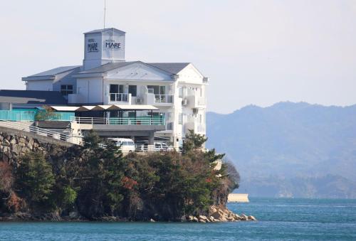 a large white house on top of a hill in the water at Hotel Mare - Vacation STAY 58144v in Kure