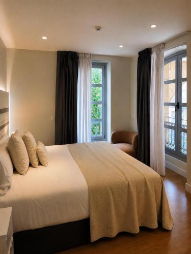 a bedroom with a large bed and a window at Legazpi Doce Rooms & Suites in San Sebastián