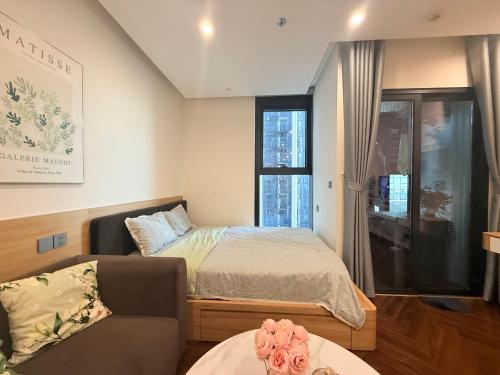 a bedroom with a bed and a couch and a window at Mai home in Hai Phong