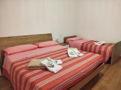 two beds in a room with towels on them at GUBBIO LIVING - by Angeloni in Gubbio
