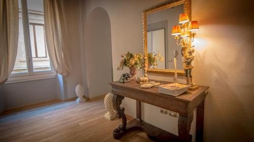 a dressing table with a mirror and a lamp at Stunning Apt 5min Walk to Duomo in Florence