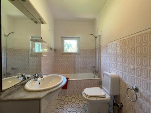 a bathroom with a sink and a toilet and a tub at Geres - Gateway House - Terras de Bouro in Terras de Bouro