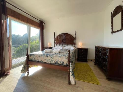 a bedroom with a bed and a large window at Geres - Gateway House - Terras de Bouro in Terras de Bouro