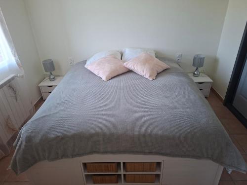 a bed with two pink pillows on top of it at Le puny in La Motte-en-Champsaur