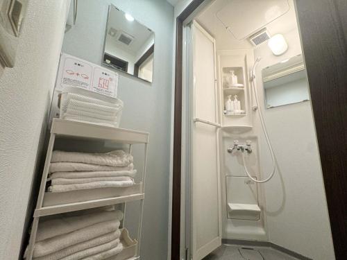 a bathroom with towels on a shelf in a shower at D Hotel - Vacation STAY 89642v in Tokyo