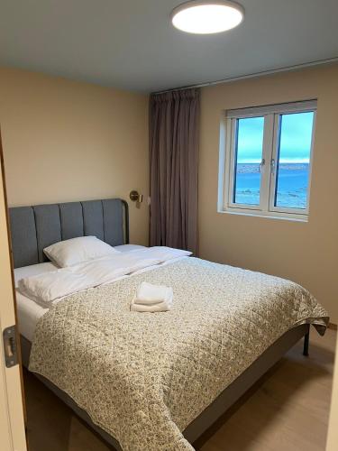 a bedroom with a bed with a towel on it at NEW house by the beach in Andøya
