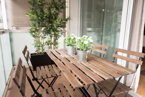 uma mesa de madeira com vasos de plantas num alpendre em Alcam Aribau em Barcelona