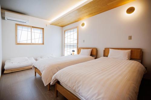 two beds in a room with two windows at Sunlight - Vacation STAY 73377v in To-katta