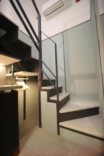 a spiral staircase in a room with a wall at Heritage Collection on KG - Mobile App Check-In in Singapore