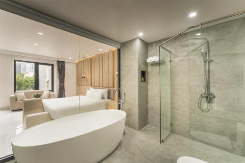 a bathroom with a bath tub and a bedroom at A89 West Lake Hotel in Hanoi