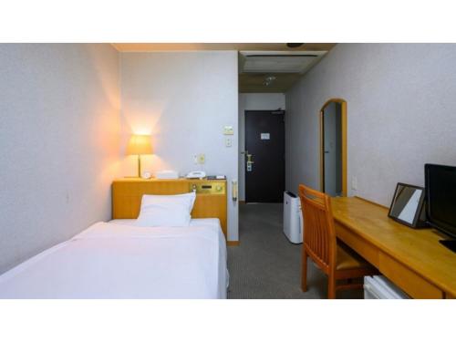 a hotel room with a bed and a desk and a television at Hotel Symphony - Vacation STAY 48763v in Sagae