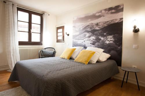 - une chambre avec un lit et 2 oreillers jaunes dans l'établissement Gîte L'Atelier, à Kaysersberg