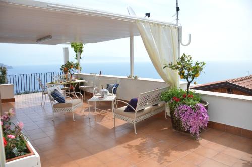 un patio avec une table et des chaises sur un balcon dans l'établissement L'Attico, à Taormine
