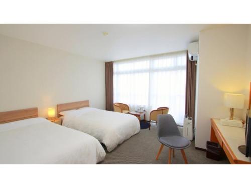 a hotel room with two beds and a chair at Hotel Symphony - Vacation STAY 85392v in Sagae