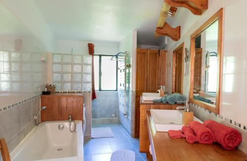 a bathroom with two sinks and a bath tub at Le palmier d'Alice in Collonges