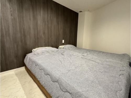 a bedroom with a large bed with a wooden wall at Monarch Hotel - Vacation STAY 43022v in Otaru