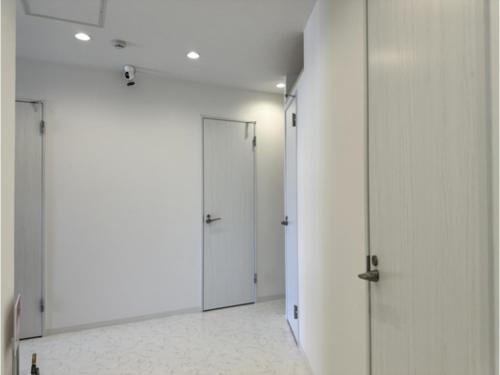 a corridor with white walls and doors in a room at Monarch Hotel - Vacation STAY 43004v in Otaru