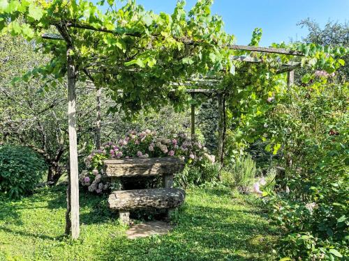 a garden with a pergola and some flowers at Holiday Home Casa Lienartova by Interhome in Grimacco