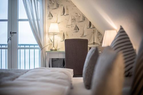 a bedroom with a bed and a desk and a window at Fakkelgaarden Hotel & Restaurant in Kruså