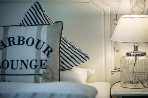 a bedroom with a pillow and a table with a lamp at Fakkelgaarden Hotel & Restaurant in Kruså