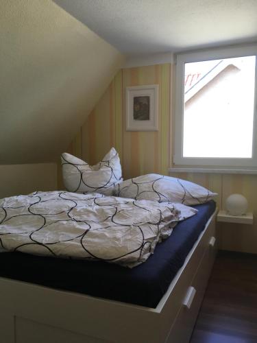 a bedroom with a bed and a window at Ferienhaus Kirchturmblick bei Quedlinburg in Hoym