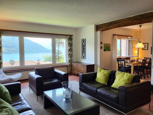 a living room with couches and a large window at Holiday Home Stellina del Sole by Interhome in Brissago