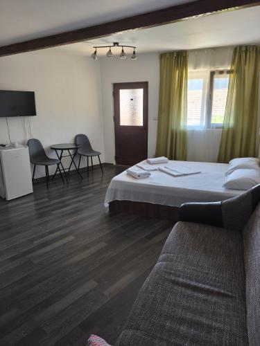 a bedroom with a bed and a table and chairs at Casa Rodica in Dubova